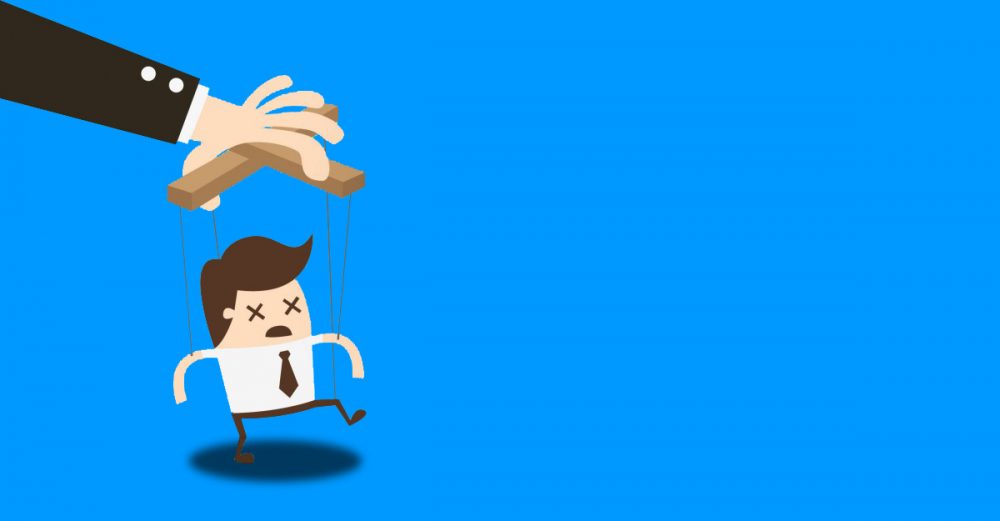 The hand of a puppet master using an office worker as a puppet.